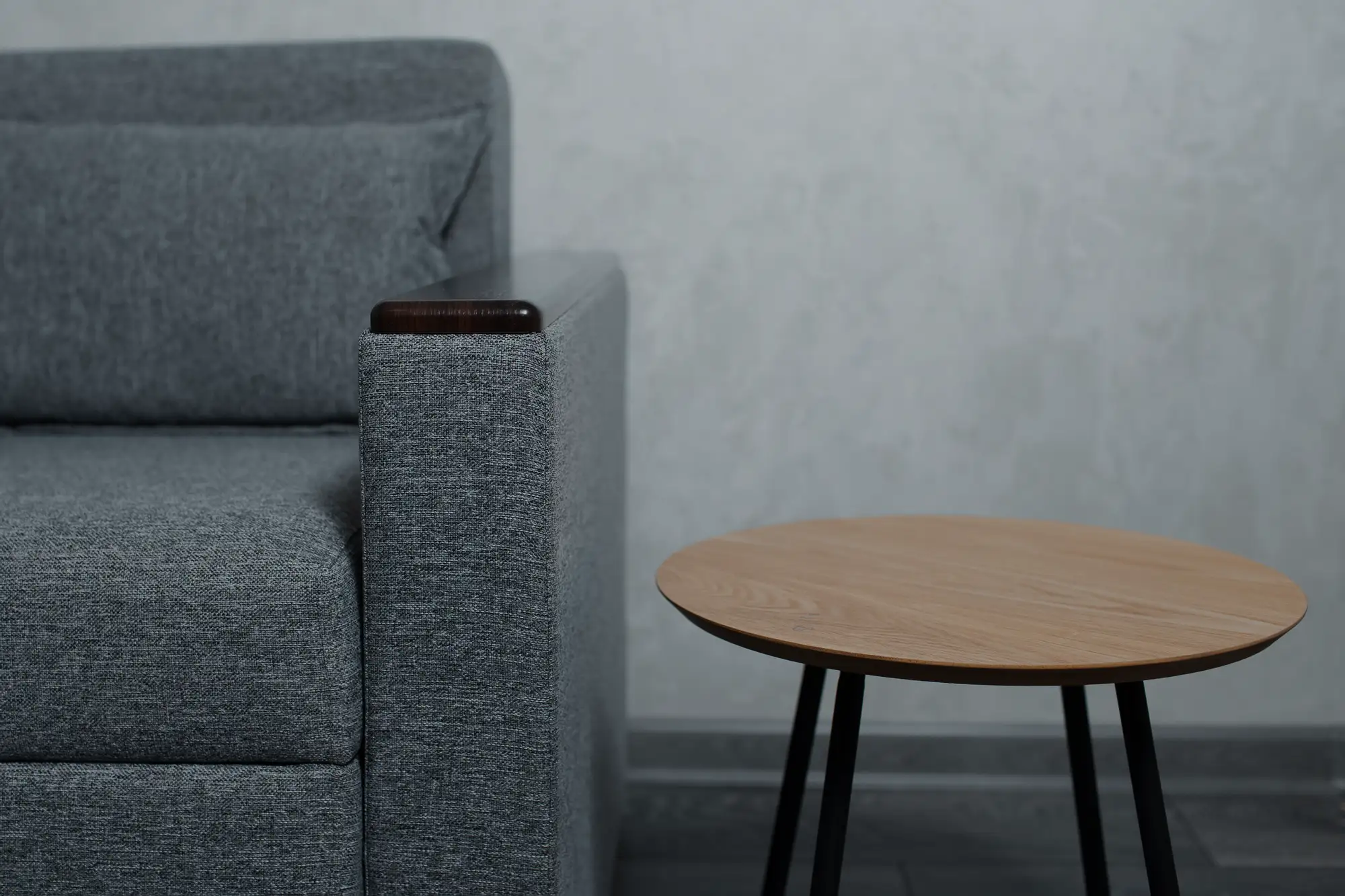 closeup small wooden round table near grey sofa background textured wall 379201 3051